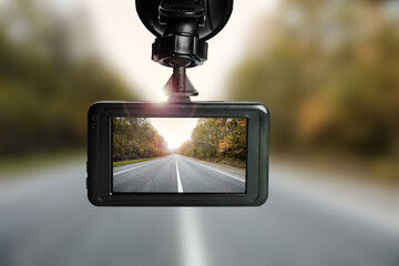 Modern dashboard camera mounted in car, view of road during driving