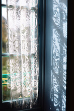 A Blue Window With A Lace Curtain