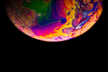 Wall Mural - Bubble color. Globe planet earth in galaxy universe space with abstract sun on black background. Color abstract fluorescent inks in water.