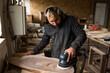 © Gabriel (Gabi) Bucataru/Stocksy - Woodworker in a shop sanding