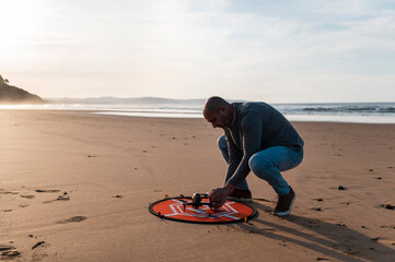 Man preparing drone for flying on beach 