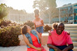 © Erin Brant/Stocksy - Loving Black family on steps outdoors