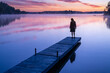 © JP Danko/Stocksy - Woman On Cottage Dock Enjoying Quiet Colorful Sunrise on Northern Lake