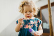 © Melissa Milis Photography/Stocksy - Young girl blowing bubbles outdoors