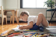 © Anna Tabakova/Stocksy - Little boy drawing on the floor