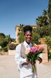 © Lucas Ottone/Stocksy - Smiling woman holding a flower bouquet