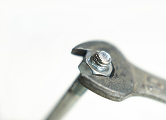 The old wrench tighten the bolt and nut on white background.