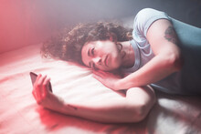 Young woman using phone on bed