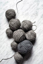 Balls Of Grey Yarn On A Simple Marble Backdrop