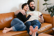 © Leah Flores/Stocksy - Couple Laughing Together Watching TV