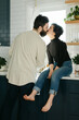 © Leah Flores/Stocksy - A Couple Shares a Kiss in the Kitchen