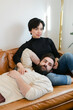 © Leah Flores/Stocksy - Affectionate Couple Reclined on Couch