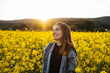 © Guaita Studio/Stocksy - Happy Young woman in flowers field during sunset