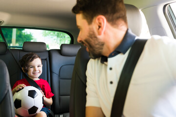 Wall Mural - Handsome man driving his cute son to class