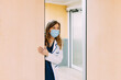 © VICTOR TORRES/Stocksy - Real nurse in white uniform and white coat in hospital corridor