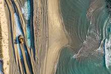 Aerial View Of A Bulldozer Moving Sand On The Beach