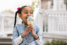 Young Girl Looks To Side While Eating An Ice Cream Cone