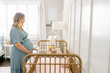 © Alison Winterroth/Stocksy - A pregnant woman looks longingly at her crib