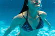 © Manu Prats/Stocksy - Crop of woman wearing bikini swimming underwater