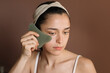 © Alberto Bogo/Stocksy - Young Woman Massaging Her Face With A Gua Sha Tool
