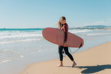Female Surfer At The Beach During Sunny Day