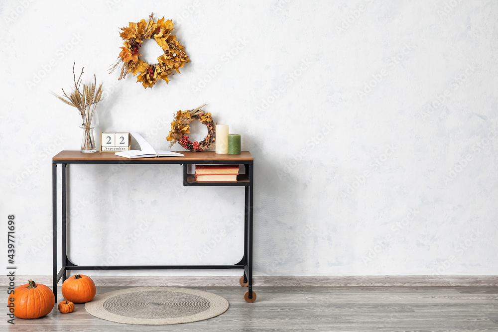 Table with autumn decor in interior of room