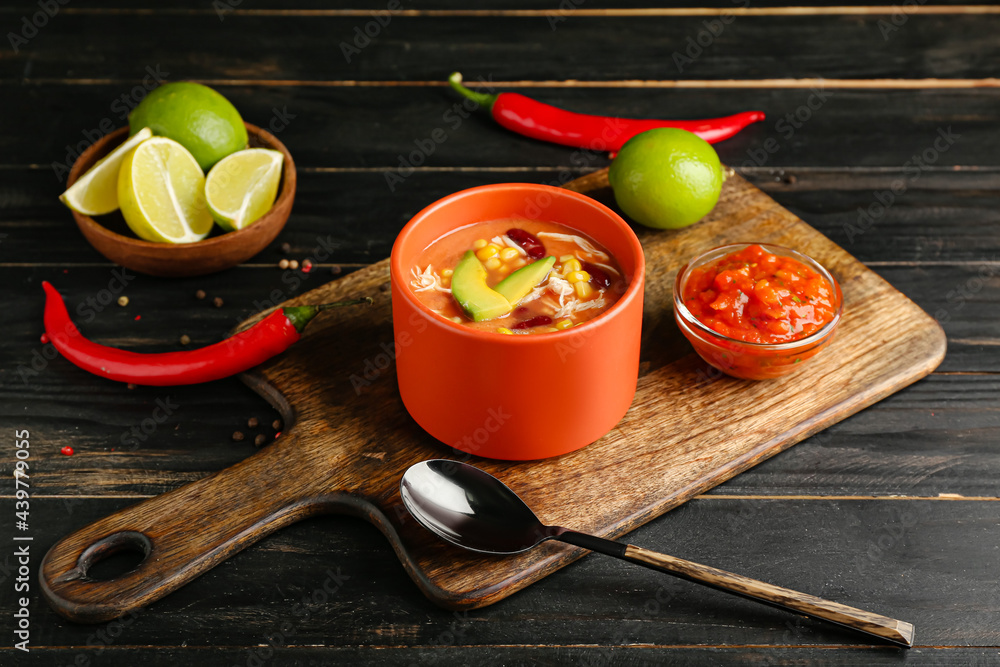 Bowl of tasty chicken enchilada soup on table