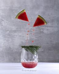 Canvas Print - Creative shot of a glass of cocktail with watermelon juice drops