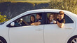 © Studio Romantic - Hiking and traveling concept. Group of young smiling hikers tourists sitting in car and going to mountains for hiking together during summer vacations on sunny day