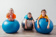 © oksix - Cute kids balancing laying on large fitballs