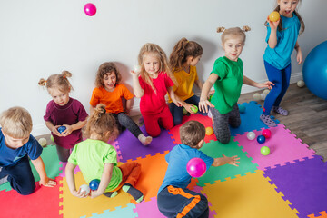 Wall Mural - Energetic youngsters throwing away many colorful balls