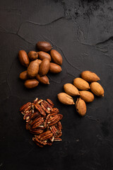 Wall Mural - Three heaps of pecan on black table top view