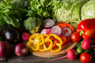 Poster - Variety of vegetables and chopped peppers and red onions on a board