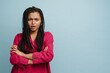 © Drobot Dean - Young black woman with pigtails frowning while holding arms crossed
