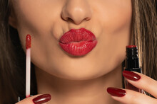 A Woman Advertises A Red Lip Gloss