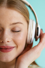 Young Blonde Woman Smiling While Listening Music With Headphones