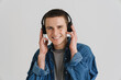© Drobot Dean - Young brunette man smiling and listening to music with headphones