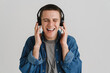 © Drobot Dean - Young brunette man smiling and listening to music with headphones