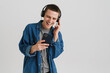 © Drobot Dean - Young brunette man with headphones smiling and holding cellphone