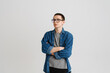 © Drobot Dean - Young man in eyeglasses looking aside and holding arms crossed