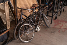 Closeup Of An Old Bicycles On A Storage Room Together With Other Unused Metal Frames And Woods