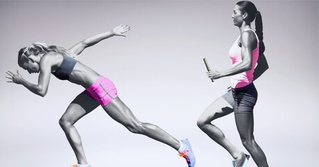 Wall Mural - Two diverse female athletes holding baton running against grey background