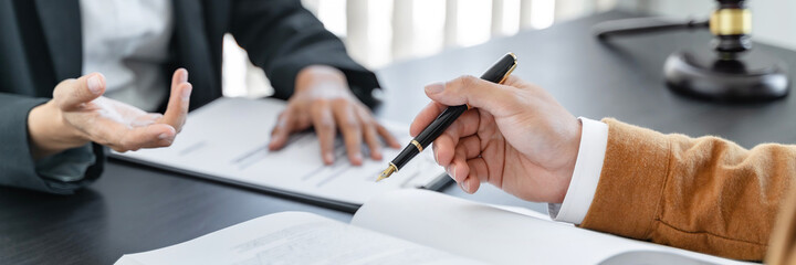 Wall Mural - Lawyer preparing to sign a contract and wooden gavel on table justice and law concept.