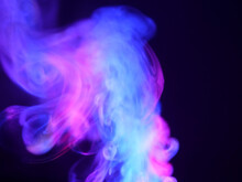 Abstract Color Series. Composition Of Colorful Smoke In Motion. Fusion Of Purple And Blue Mist Isolated On A Dark Background To Inspire Creativity.