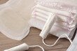 Absorbent menstrual pads and tampons on wooden table closeup