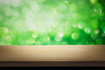 Wall Mural - Green bright lights bokeh background of wooden table in nature of abstract blurred and space use for product