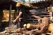 © Manu Prats/Stocksy - Man cutting wood with chainsaw at sawmill