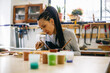 © Inuk Studio/Stocksy - Young craftswoman coloring wooden detail in workshop