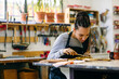 © Inuk Studio/Stocksy - Young craftswoman coloring wooden detail in workshop