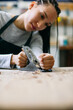 © Inuk Studio/Stocksy - Skilled female woodworker working with jointer